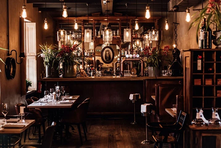 Warmly lit dining room and bar at The Fat Butcher in Stellenbosch