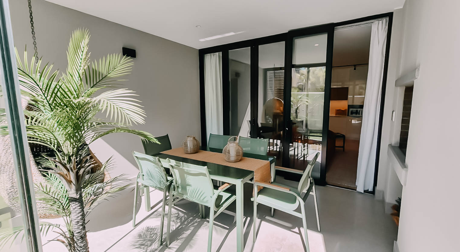 Covered outdoor dining area beside the sliding doors to the lounge in the superior two garden apartment at Aan de Meul