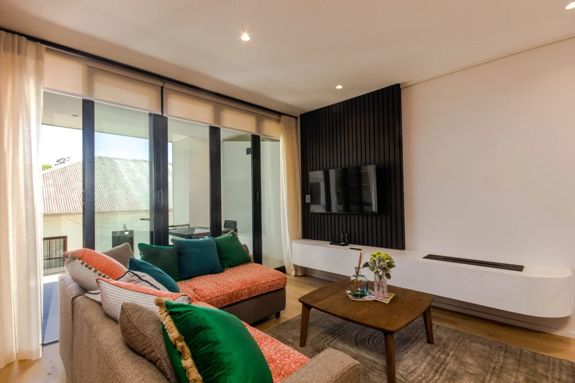 Lounge with colourful cushions opening to the private balcony in the Luxury Two Bedroom with Balcony apartment at Aan de Meul