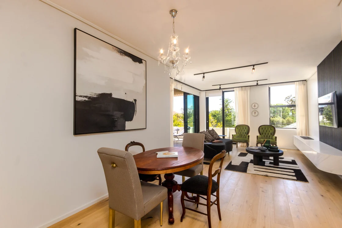 Penthouse dining area leading through to the lounge and elevated balcony in the Two Bedroom Penthouse apartment at Aan de Meul